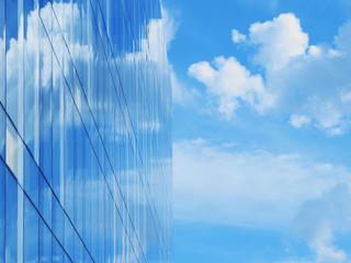 glass office building blue sky and clouds
