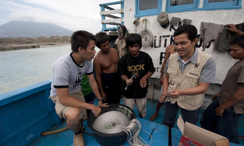 Demonstrating a bycatch de-hooker to longline tuna fishing boat crew