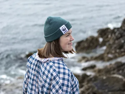 WWF's Bailey Moritz looks out towards the right on a rocky shoreline.