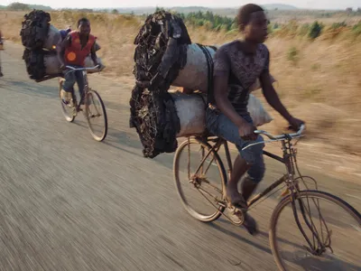 men transport charcoal by bicycle