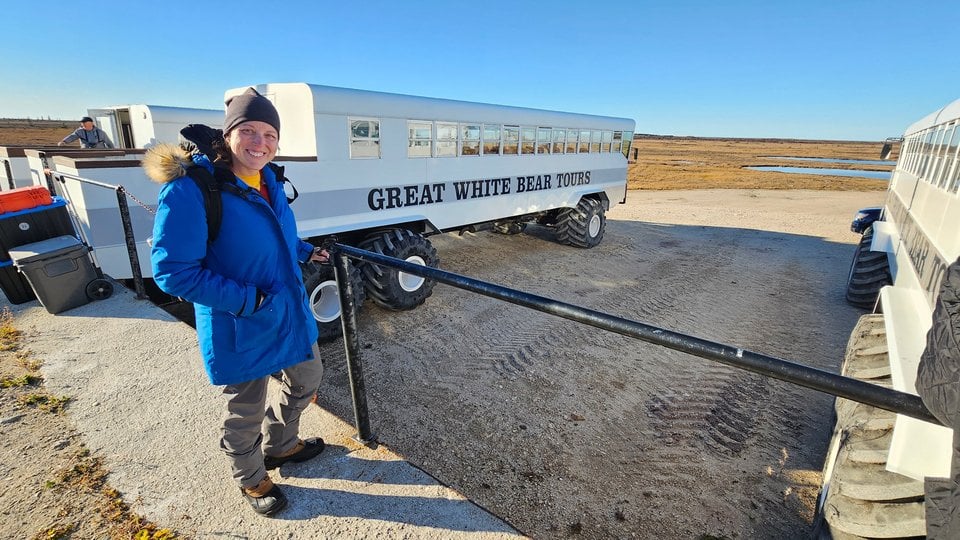 Koleen stands next to Great White Bear Tours bus