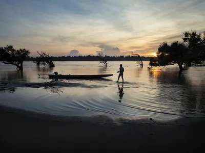 Fisherman cleaning boat at sunset
