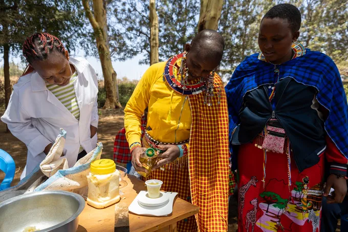A woman pours honey into a cup