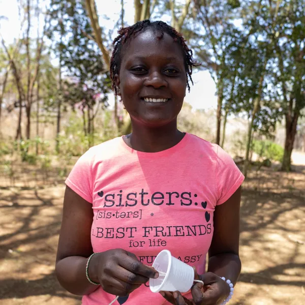 A teenage girl holds one of the candles that she made