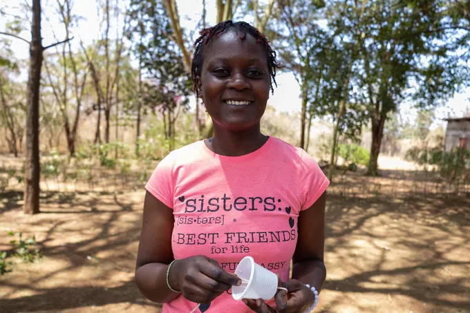 A teenage girl holds one of the candles that she made