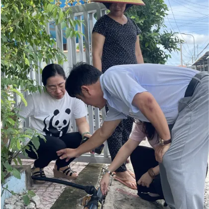 Three people examine a water pipe