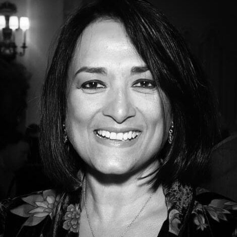 A black and white photo of a woman smiling.