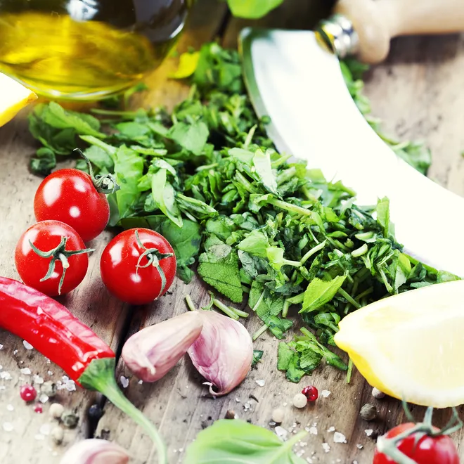 Vegetables sit on a table next to a knife