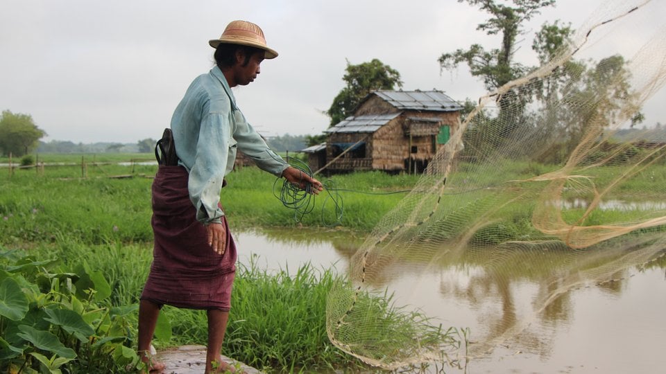 A man throws a fishing net in Myanmar