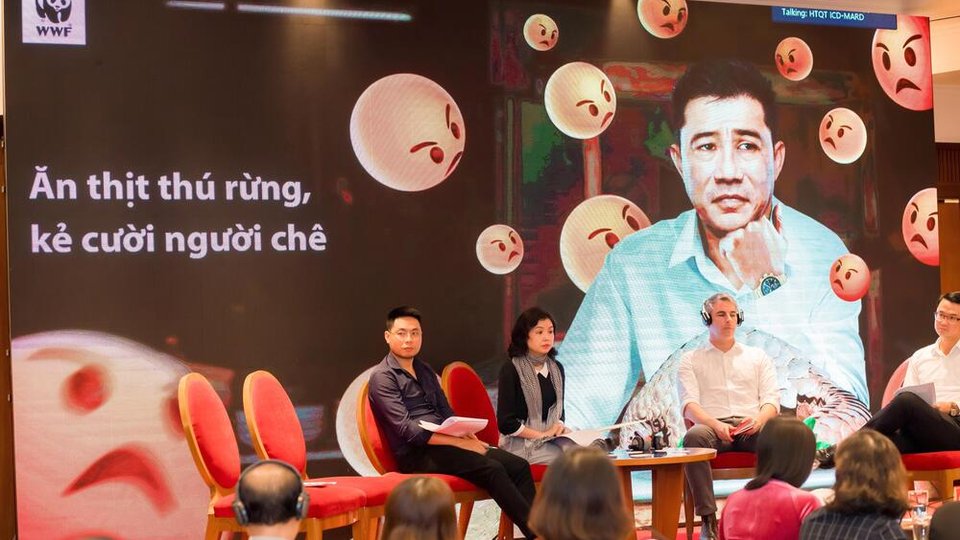 People sit in front of a WWF banner in Vietnamese