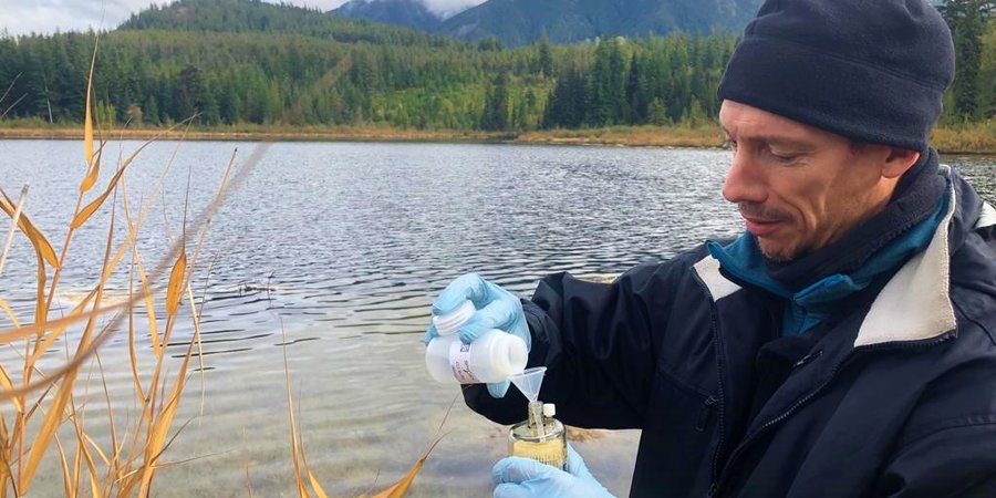 Arnaud Lyet tomando muestras de agua para un estudio de eDNA en Columbia Británica.