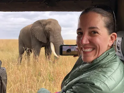 Danielle Brigida in a safari car with an elephant in the background