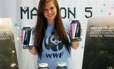 A woman wearing a blue WWF shirt holds up two water bottles at an event