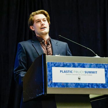 A man in business attire standing behind a podium.