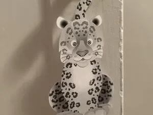 A photo showing a crafted door hanger in the shape of a snow leopard.