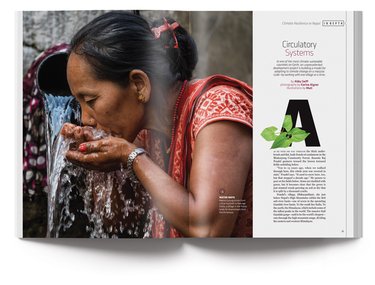 Magazine open to article on Nepal that shows an image in the magazine of a woman in a red dress drinking water