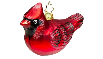 A red bird ornament against a white background