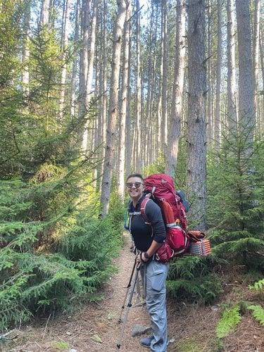 Jeamme Chia hiking in the woods with a large backpack