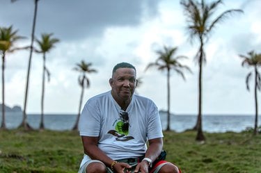 A man sitting outside under palm trees