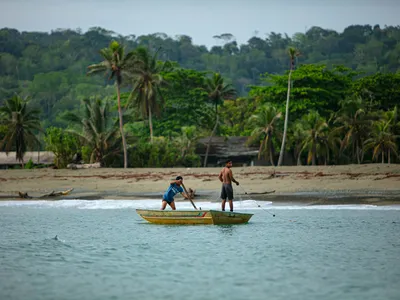 Two boys on fishing from canoes