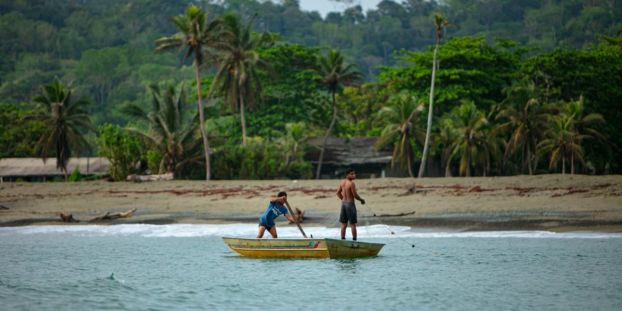 Two boys on fishing from canoes