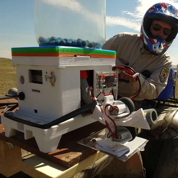 Person on ATV in open field with triple shooter device