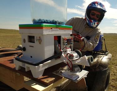 Person on ATV in open field with triple shooter device