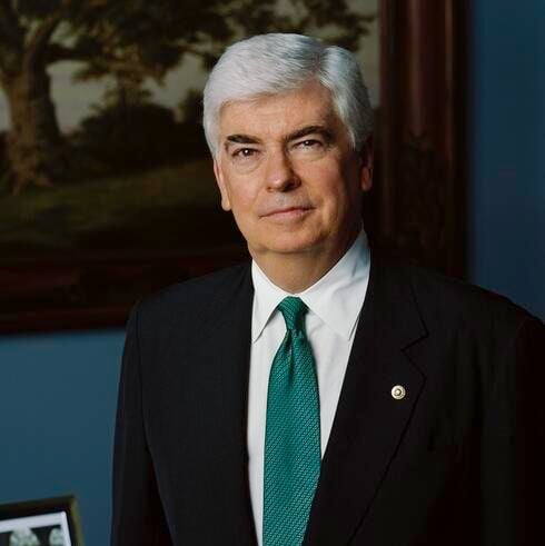 A headshot of a smiling man