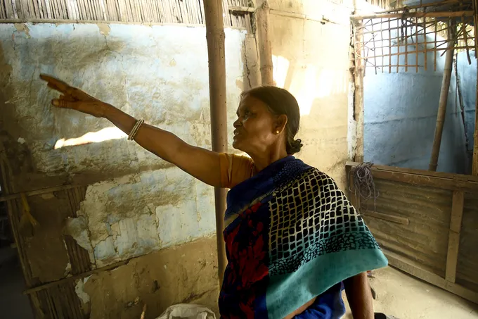 Woman pointing to house wall