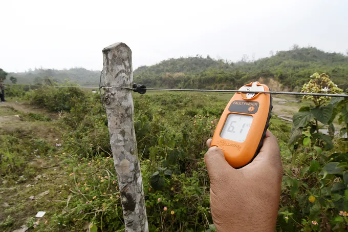 Using a tool to measure current on wire fence