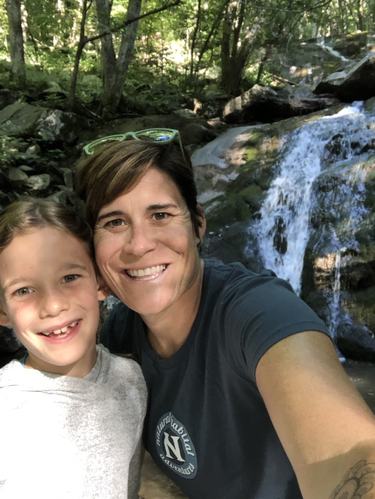 Erin Simon with her daughter in front of a waterfall