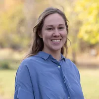 Headshot of Mary Jane Chandler in blue shirt with a fall background