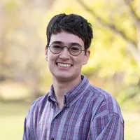 SJ Schanwald in a blue plaid shirt with a fall background