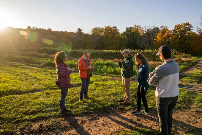 Group of people talking together in a a farm field