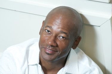 Frank Walker smiles and looks up. He is wearing a white button down.