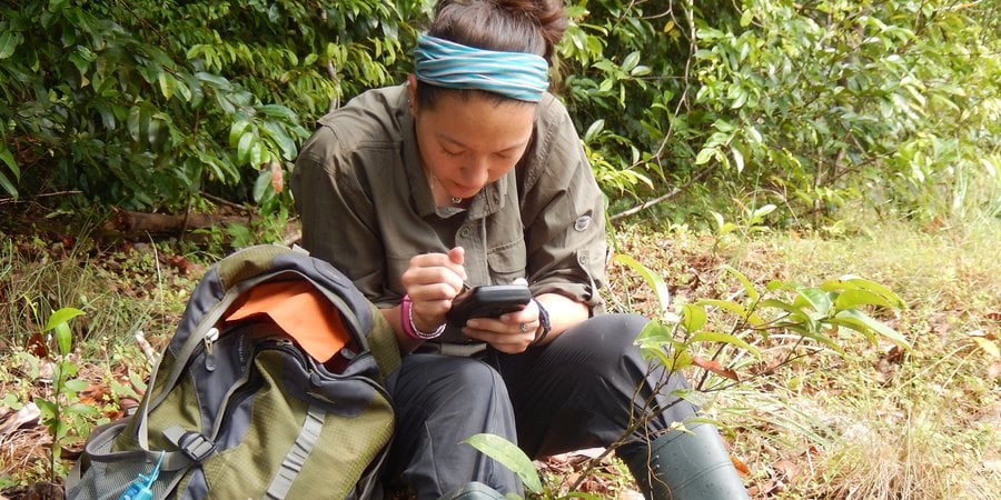 Author and scientist Emily Mills uses a handheld GPS device to track elephant movements