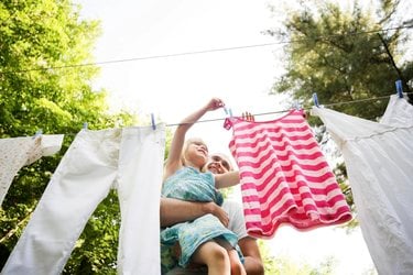 Father and daughter hang laundry outside