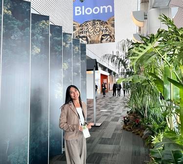 Francesca Edralin stands in front of Bloom conference signage