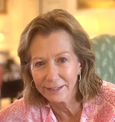 Headshot of Diana Wold in a pink shirt wtih brown hair