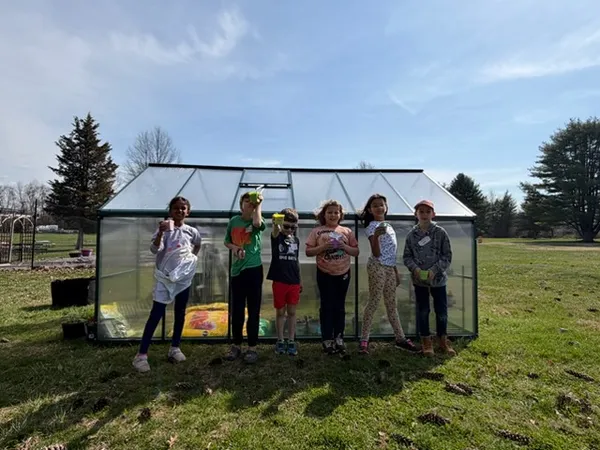 Students in front of green house