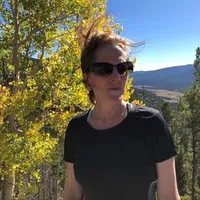 A headshot of Margaret Ackerley in the woods