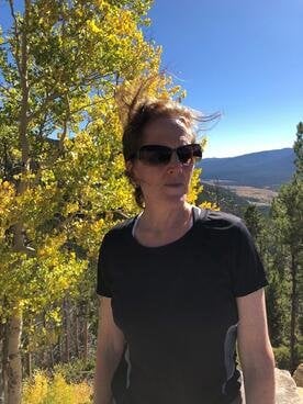 A headshot of Margaret Ackerley in the woods