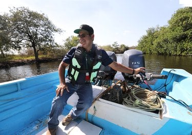 Man siting in small boat operating engine