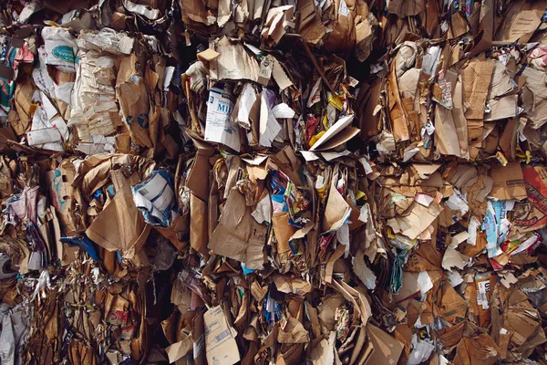 A close up of mostly brown cardboard compacted in a raw materials yard