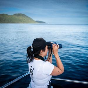 WWF Chile's Yacqueline Montecinos looks through binoculars at the waters off Guafo Island, Chile