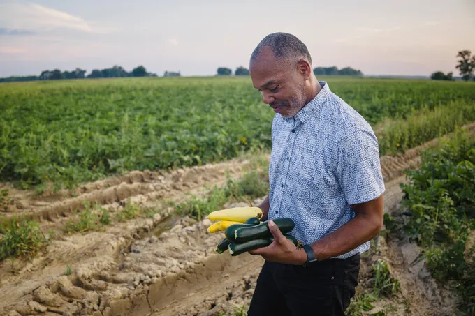 Harvey Williams holding squash in a field