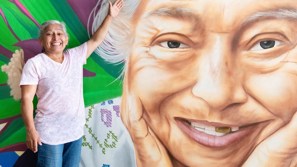 Canul Díaz stands in front of a mural of her mother painted on the side of the community center in Tzucacab, Yucatán, Mexico