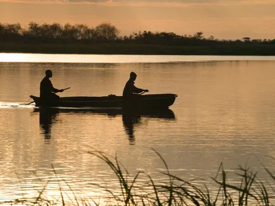 Fishermen at sunset returning after fishing on the Kafue River, Zambia