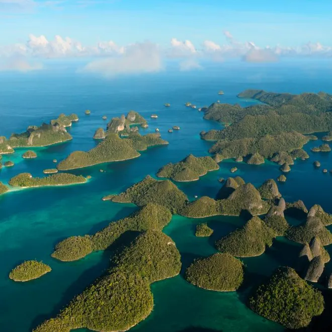 Aerial photo of green islands rising from blue ocean