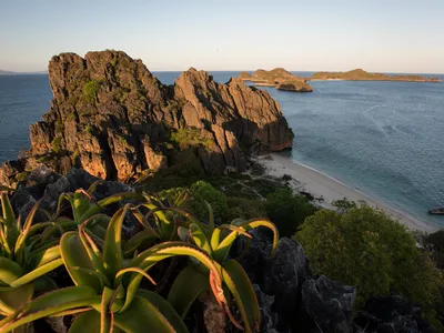 A view of the Nosy Hara Island that has tall, rocky outcroppings with greenery on top and ocean all around